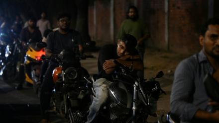 Un homme fait la sieste sur sa moto dans une file d'attente pour du carburant à Dacca, capitale du Bangladesh, le 21 avril 2026