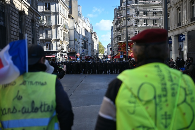 Des manifestants portant des gilets jaunes font face à des gendarmes place de la République à Paris le 17 octobre 2026 