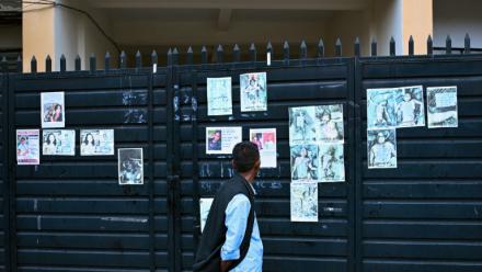 Un homme regarde les photos de personnes mortes ou portées disparues dans la crue destructrice qui a fait plus de 600 morts à la frontière entre le Népal et la Chine, le 29 août 2026 à Katmandou