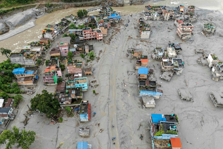 Vue aérienne de maisons recouvertes de boue et les débris après par la crue destructrice qui a fait plus de 600 morts à la frontière entre le Népal et la Chine, le 29 août 2026 à Devighat, dans le district népalais de Nuwakot