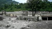 Un homme marche au milieu des décombres après la crue destructrice dans l'Himalaya, le 30 août 2026 à Trishuli, dans le district népalais de Nuwakot 