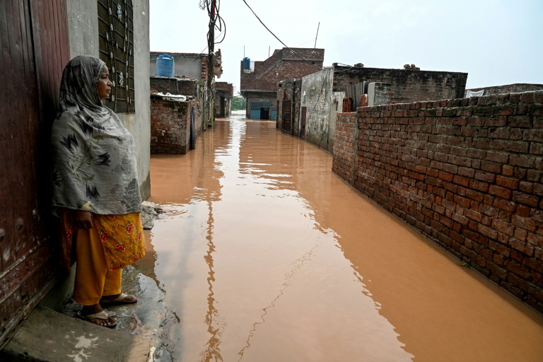 Ghulam Bano près de sa maison submergée par les eaux en crue du fleuve Ravi à Shahdara, le 29 août 2025 au Pakistan