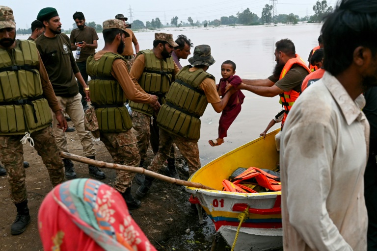 L'armée pakistanaise et des secouristes évacuent en bateau les habitants après après la crue des eaux du fleuve Ravi à Lahore, le 29 août 2025 au Pakistan