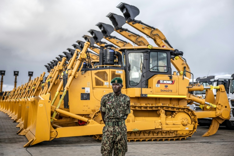 Un membre du Service national de la jeunesse (NYS) du Kenya surveille des excavatrices et autres machines lourdes stationnées avant une cérémonie d'inauguration d'une raffinerie au port de Lamu (Kenya), le 30 septembre 2026
