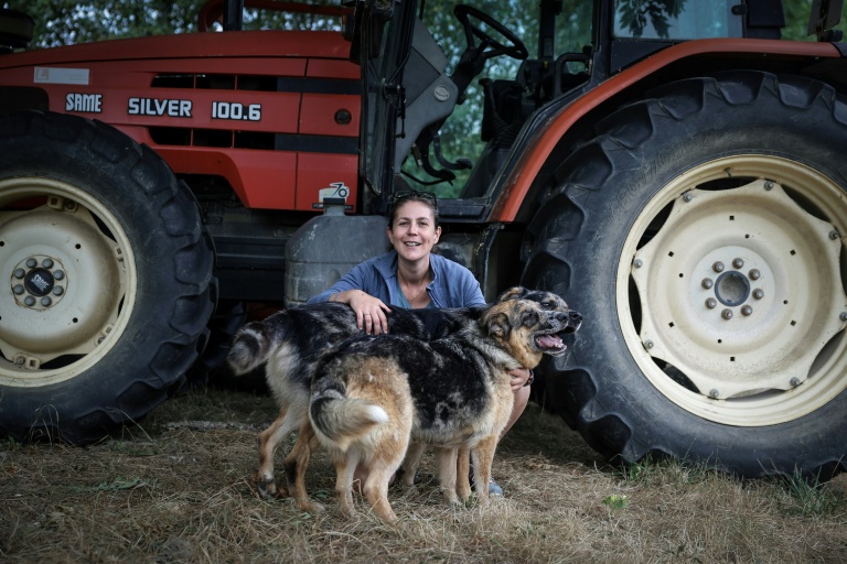 L'agricultrice Élodie Lac pose avec ses chiens dans sa ferme biologique à Cézac (Lot), le 19 août 2025