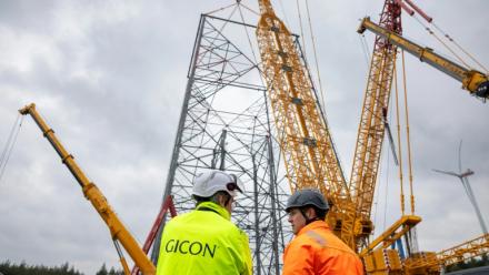 Jochen Grossmann, à gauche, PDG du groupe GICON, et le chef de projet Frank Adam, à sa droite, devant le chantier de la plus haute éolienne du monde à Schipkau, en Allemagne, le 13 mai 2026
