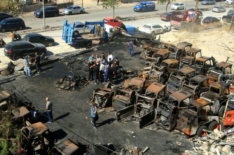 Des personnes se tiennent au milieu de matériels agricoles calcinés, sur le site d'une frappe israélienne nocturne dans le village de Msaileh, au sud du Liban, le 11 octobre 2025
