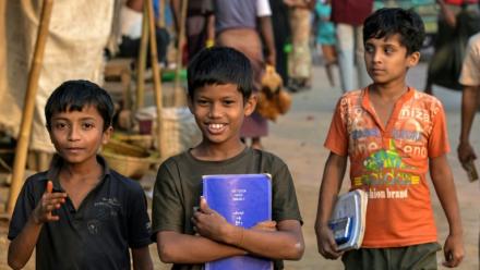Des enfants réfugiés rohingyas portent leurs manuels scolaires au camp de réfugiés de Kutupalong, le 17 décembre 2025 à Ukhia, au Bangladesh