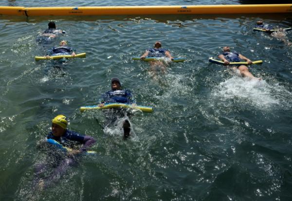 Des mères des quartiers Nord de Marseille participent à un cours de natation dispensé par l'association "Le Grand Bleu" dans une piscine d'eau de mer près du port de l'Estaque, le 11 août 2025