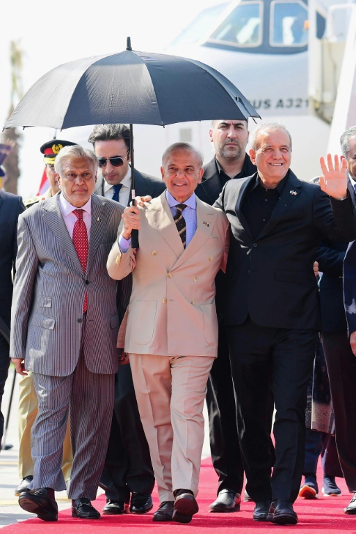 Photo diffusée et prise par le bureau du Premier ministre pakistanais le 23 juin 2026, montrant le Premier ministre pakistanais, Shehbaz Sharif (ac), le ministre pakistanais des Affaires étrangères, Ishaq Dar (g) aux côtés du président iranien, Massoud Pezeshkian (d), à son arrivée à la base aérienne Nur Khan de Rawalpind, au Pakistan