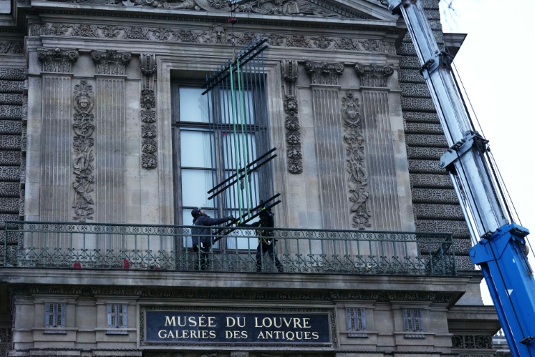 Des ouvriers installent une grille de protection devant la fenêtre de la galerie d'Apollon du  musée du Louvre, le 23 décembre 2025 à Paris