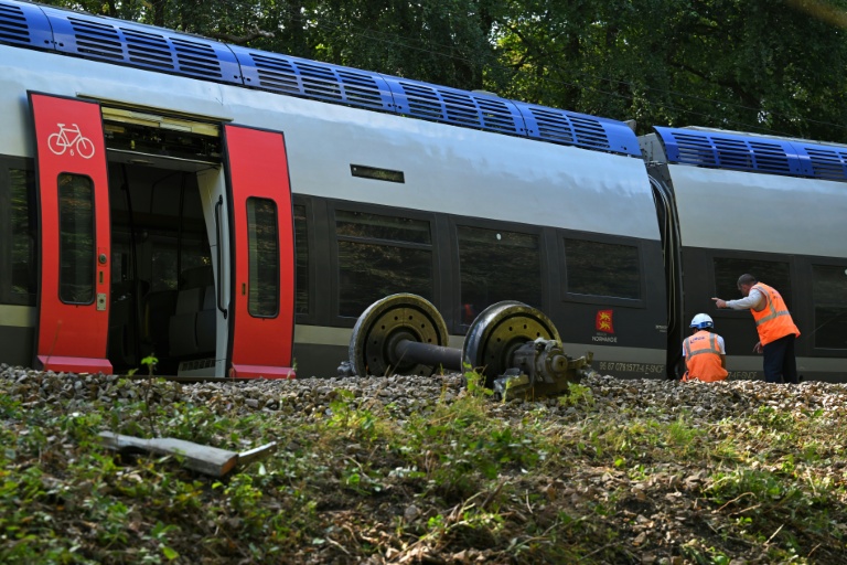 Le 12 septembre 2026, des agents ferroviaires inspectent le TER qui a déraillé la veille, faisant 44 blessés à Cléon, en Seine-Maritime