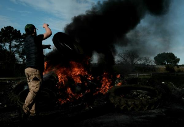 Le 16 décembre 2025, un agriculteur français jette un pneu sur un bûcher installé sur l'autoroute A63, bloquée dans les deux sens à l'échangeur de Cestas, en Gironde