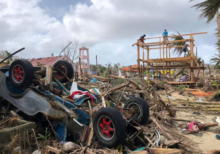 Des habitants reconstruisent une maison après le passage du typhon Rai en décembre 2021, le 3 janvier 2022 à Burgos, sur l'île de Siargao, aux Philippines