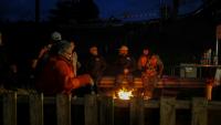 Des participants au blocage de l'autoroute A63 à Cestas, au sud de Bordeaux, sont rassemblés autour d'un feu le 24 décembre 2025