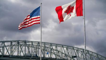 Les drapeaux américain et canadien près du poste frontalier du pont Blue Water à Point Edward, en Ontario, le 24 octobre 2025 au Canada