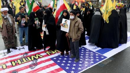 Photo réalisée avec l'accord du ministère de la Culture et de l'Orientation islamique iranien d'Iraniens qui marchent sur un drapeau américain lors d'une commémoration en soutien au peuple palestinien, à Téhéran, le 13 mars 2026
