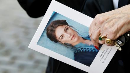 Un portrait de Nadia Farès tenu par une participante à ses obsèques, à Paris, le 24 avril 2026