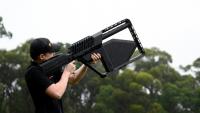 Un membre de l'équipe DroneShield tient un fusil "DroneGun" à Sydney, le 9 février 2026 en Australie