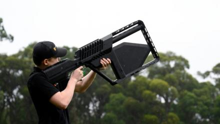 Un membre de l'équipe DroneShield tient un fusil "DroneGun" à Sydney, le 9 février 2026 en Australie