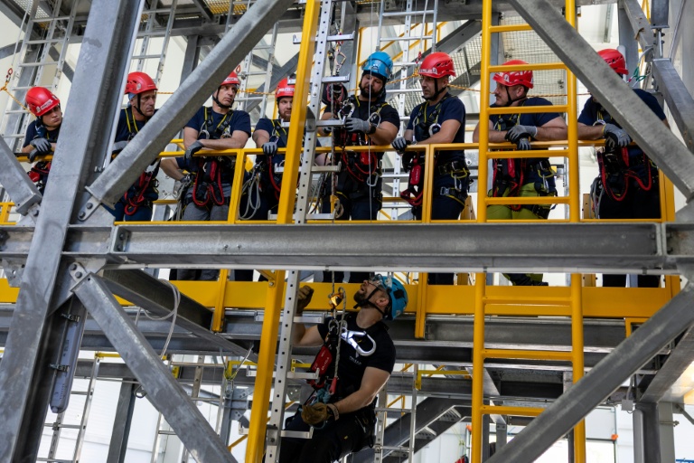 Des mineurs apprennent des techniques d'évacuation lors d'une formation à la sécurité, au sauvetage et à l'évacuation pour le travail en hauteur, au centre de formation Vulcan à Szczecin, dans le nord-ouest de la Pologne, le 23 juin 2026