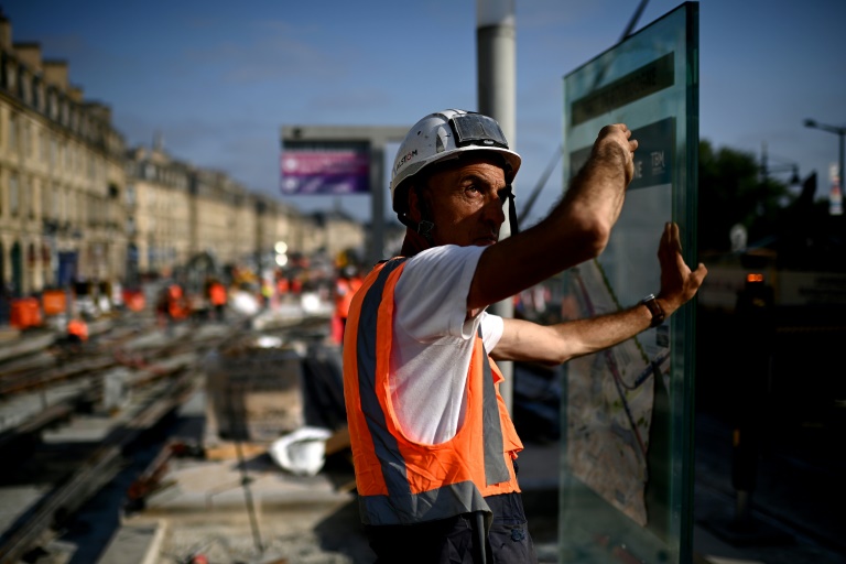 Un ouvrier travaillante sur un chantier de lignes de tramway le long de la Garonne se protège du soleil pendant une vague de chaleur à Bordeaux, dans le sud-ouest de la France, le 1er juillet 2025