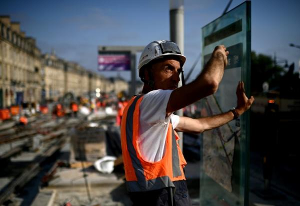 Un ouvrier travaillante sur un chantier de lignes de tramway le long de la Garonne se protège du soleil pendant une vague de chaleur à Bordeaux, dans le sud-ouest de la France, le 1er juillet 2025
