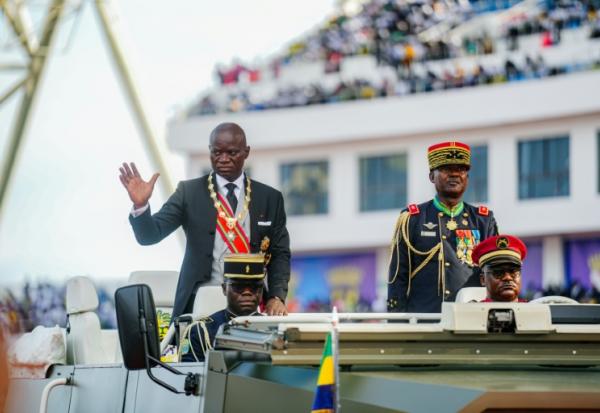 Le président du Gabon Brice Oligui Nguema (g) salue la foule au cours d'une cérémonie dans un stade de Libreville, le 3 mai 2025