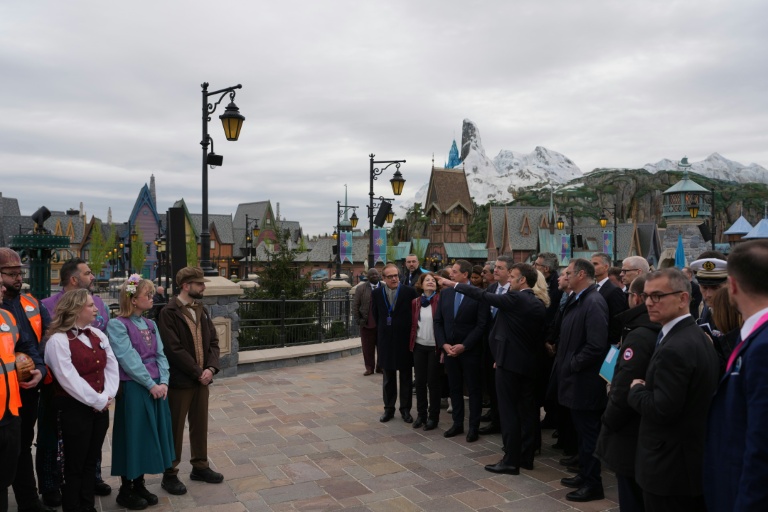 Le président Emmanuel Macron (au centre) à l'inauguration du nouveau parc à thème « Le Monde de La Reine des neiges » à Disneyland Paris, à Marne-la-Vallée, à l'est de Paris, le 27 mars 2026.