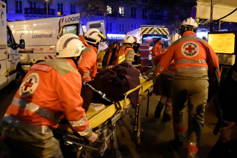 Des membres de la Croix-Rouge française portent secours à des victimes près de la salle de concert du Bataclan à Paris, le 13 novembre 2015