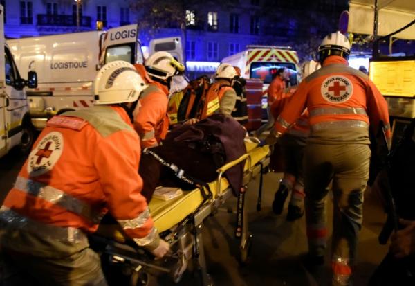 Des membres de la Croix-Rouge française portent secours à des victimes près de la salle de concert du Bataclan à Paris, le 13 novembre 2015