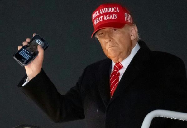 Le président américain Donald Trump, un smarthphone à la main, débarque d'Air Force à la base Andrews, dans le Maryland, de retour de Pennsylvanie où il a avoir visité une aciérie d'US Steel