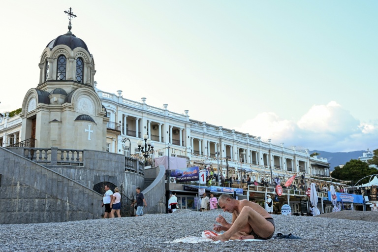 Un estivant joue aux cartes sur une plage de Yalta, en Crimée annexée, le 21 juillet 2026