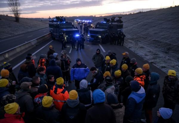 Un gendarme s'entretient avec des agriculteurs alors qu'ils sont empêchés d'entrer dans Toulouse dans le cadre de leur mouvement de protestation visant à défendre leur profession et à dénoncer la gestion de la crise agricole par le gouvernement, près de Leguevin, le 7 janvier 2026.