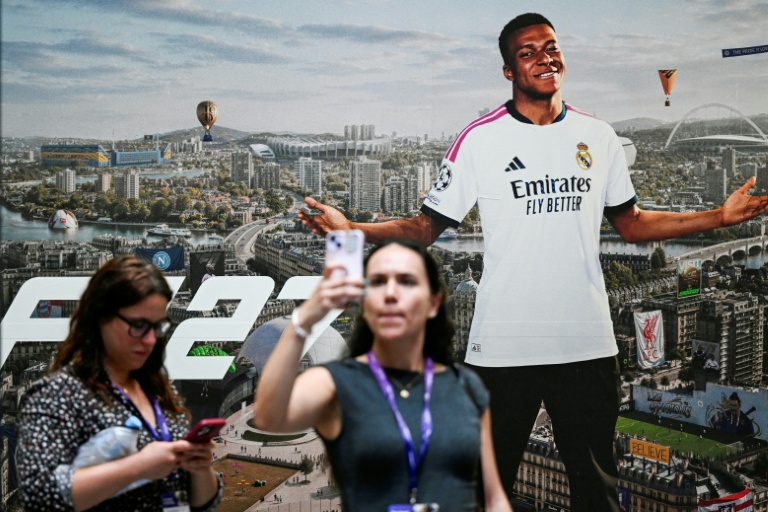 Une joueuse prend un selfie devant une publicité du jeu EA SPORTS FC 27 représentant la star française Kylian Mbappé, au salon Gamescom, à Cologne le 26 août 2026