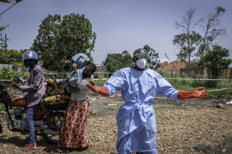 Un agent de santé demande de l'aide pour accueillir une jeune femme soupçonnée d'avoir la maladie Ebola, à l'hôpital de Rwampara, dans le nord-est de la RDC, le 26 mai 2026

