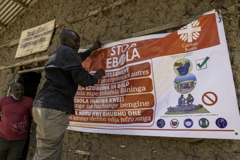 Un homme accroche une affiche de sensibilisation dans la lutte contre le virus Ebola, le 28 mai 2026 à Bunia, dans l'est de la République démocratique du Congo (RDC)