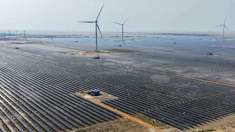 Cette photographie aérienne prise le 15 octobre 2024 montre des éoliennes et des panneaux solaires installés à la centrale d'énergie renouvelable verte d'Adani à Khavda, dans l'État indien du Gujarat