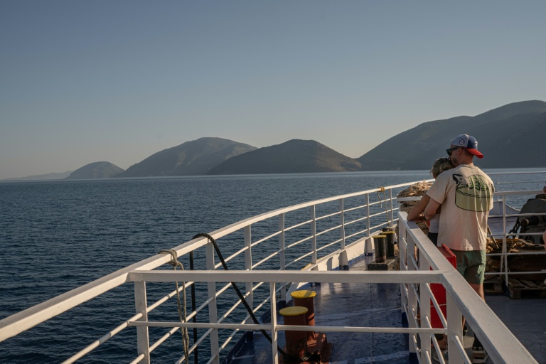 Des touristes sur le pont d'un ferry, le 3 août 2026, en route vers l'île grecque d'Ithaque, patrie d'Ulysse, héros de la mythologie grecque.
