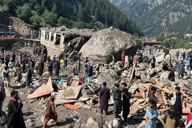 Des habitants au milieu des décombres de boutiques détruites par des crues soudaines à Parun, dans la province du Nouristan, le 21 juillet 2026 en Afghanistan