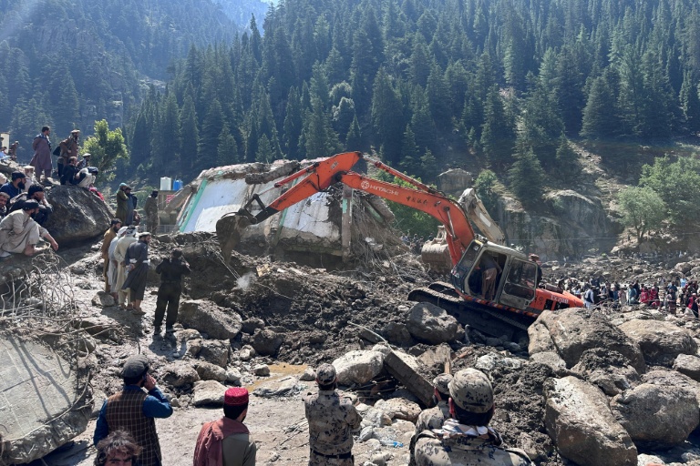 Un engin de chantier déblaient les décombres de boutiques détruites par des crues soudaines à Parun, dans la province du Nouristan, le 21 juillet 2026 en Afghanistan