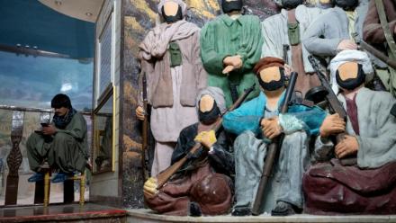 Un visiteur s'assoit près de statuettes représentant des moudjahidine sans visage au "musée du Jihad" dans la province d'Herat, en Afghanistan, le 6 janvier 2026