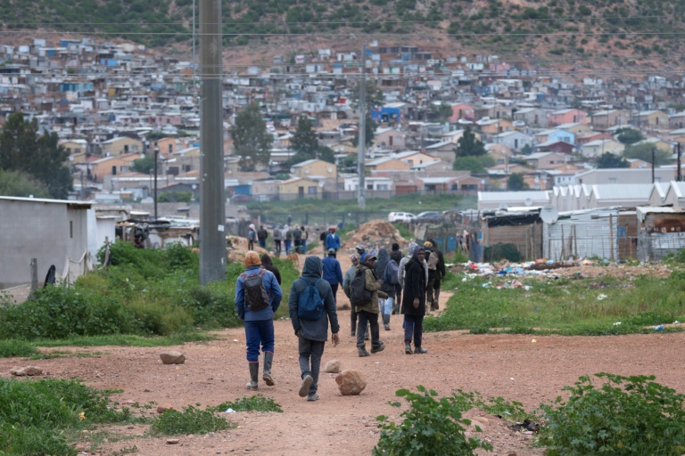 Des travailleurs, pour la plupart employés dans des fermes locales, rentrent chez eux à Nkqubela, un township et campement informel de la ville de Robertson (province du Cap-Occidental, Afrique du Sud), le 9 juillet 2026
