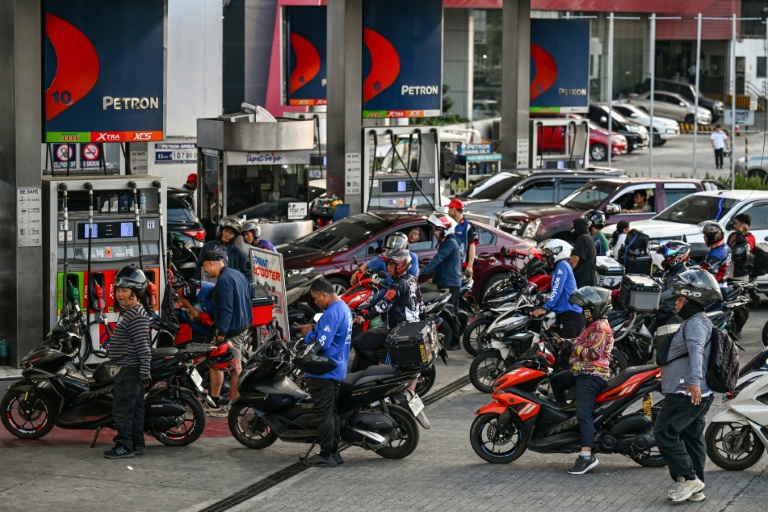 Des motocyclistes et des automobilistes font la queue à une station-service à Quezon City, dans la région métropolitaine de Manille, le 9 mars 2026 aux Philippines