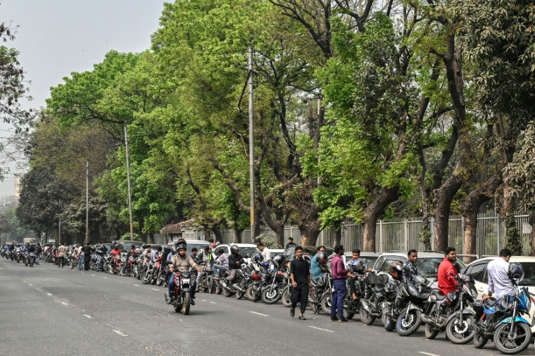 Des motocyclistes et des automobilistes font la queue pour prendre de l'essence à Dacca, le 8 mars 2026 au Bangladesh