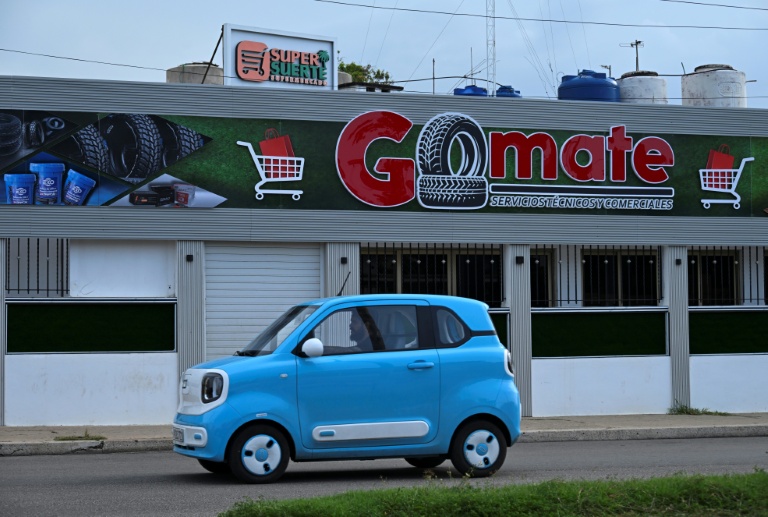 Une voiture électrique passe devant un magasin privé à La Havane, le 22 juin 2026