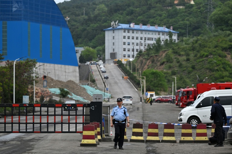 Un policier devant l'entrée de la mine de charbon de Liushenyu, où un coup de grisou dévastateur a fait au moins 82 morts, le 24 mai 2026 dans le district administratif de Qinyuan, dans la province chinoise septentrionale du Shanxi