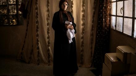 Alia al-Hallaq, la mère de Mohammed, tué à 9 ans par un soldat israélien en octobre 2025, tient le thobe de son fils, dans le village d'al-Rihiya, en Cisjordanie occupée, le 16 juillet 2026