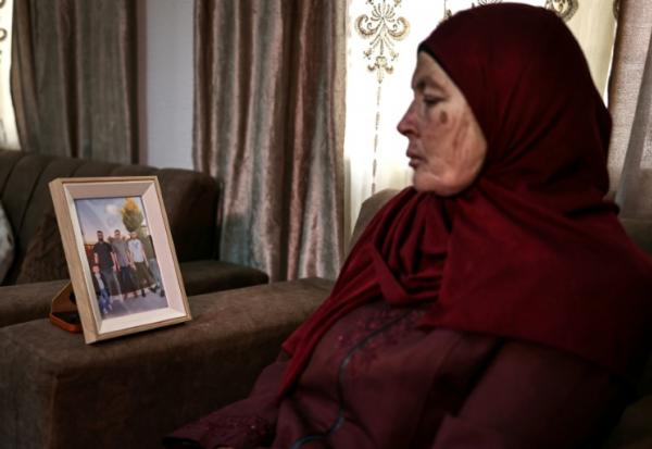 Milia Hamayel, dont le fils Thaer Hamayel a été tué lors d'une attaque de colons israéliens, regarde une photo de son fils défunt dans son village de Abou Falah, au nord-est de Ramallah, le 12 mars 2026