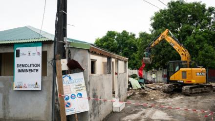 Un engin démantèle un bâtiment dans un quartier des Abymes en Guadeloupe qui doit être reconstruit, le 9 avril 2025